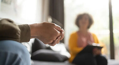 Femme qui se tient les mains en compagnie d'une professionnelle